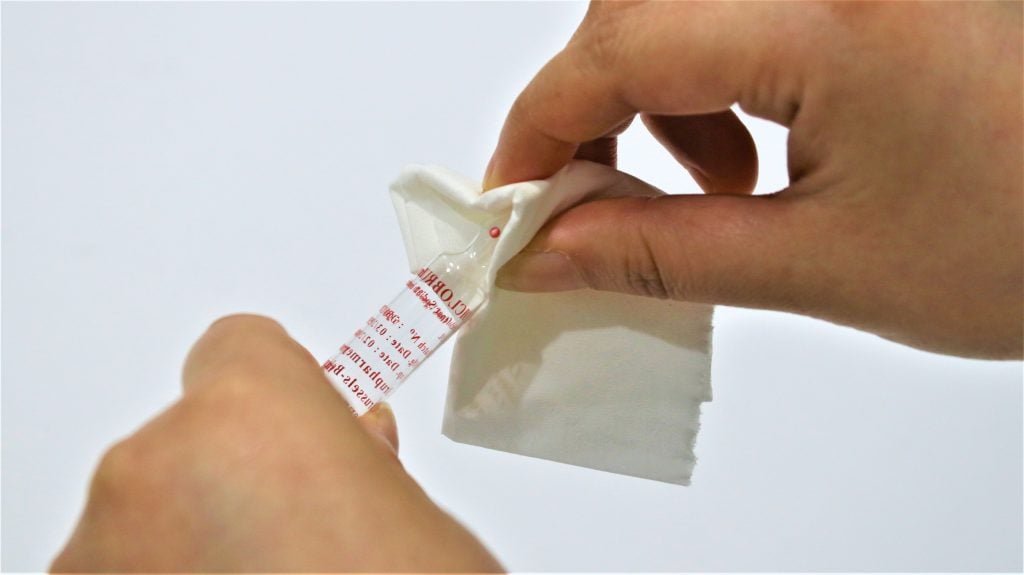 picture of beauty serum being unsafely opened with tissue